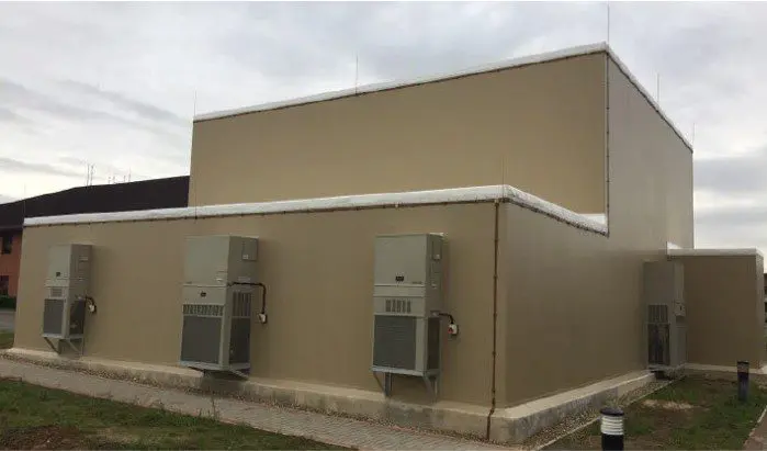 A building with two electrical boxes on the side of it.