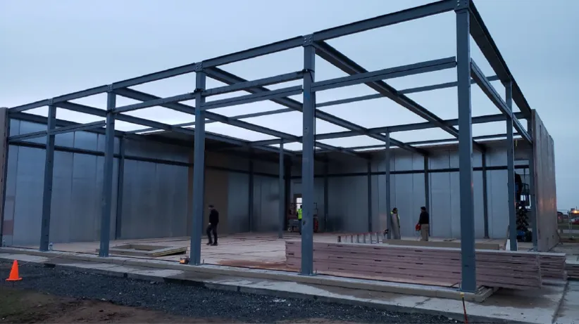 A group of people standing under an open roof.