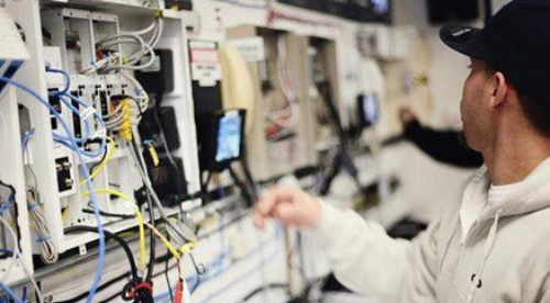 A person is holding wires in an electronics store.