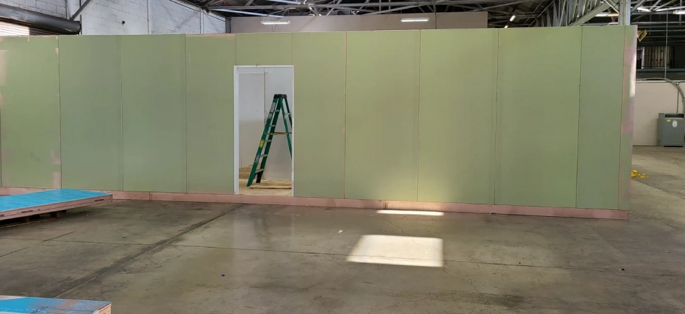 A room with green walls and a ladder in the center.