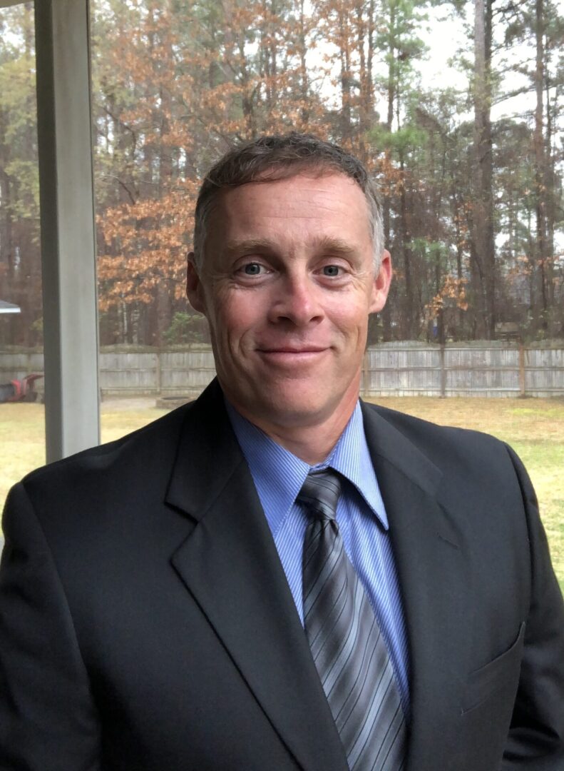 A man in a suit and tie standing outside.