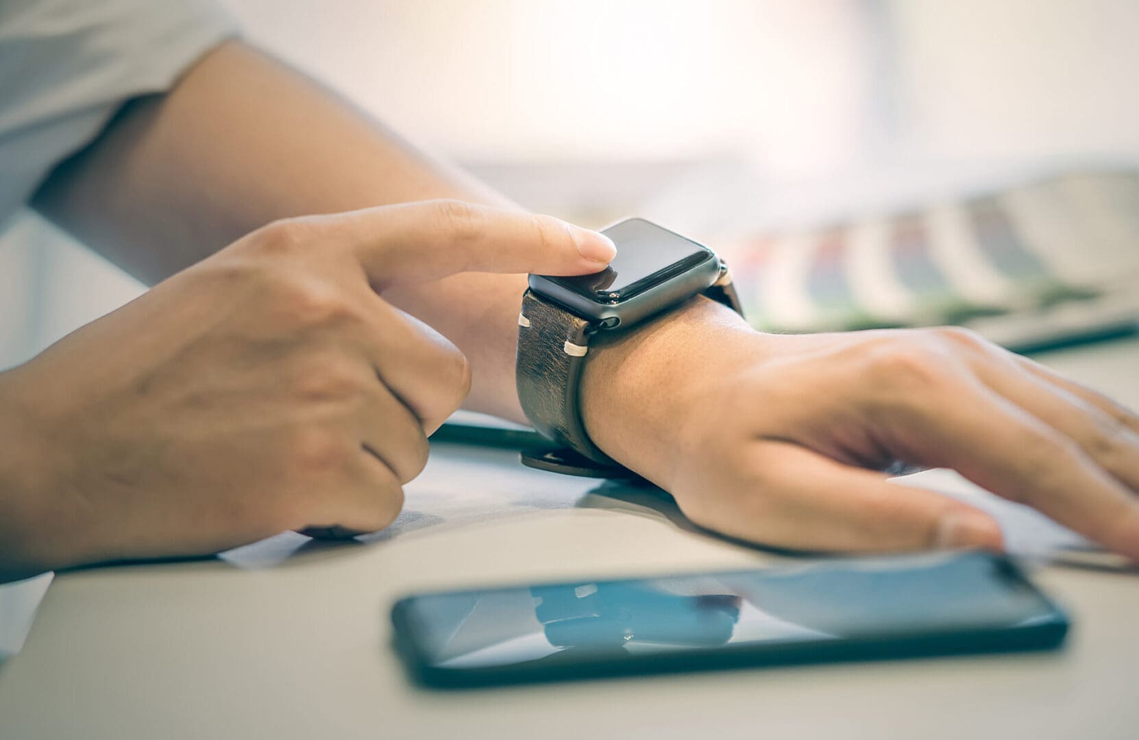 A close up of a smart watch and smart phone which would not be permitted within a SCIF